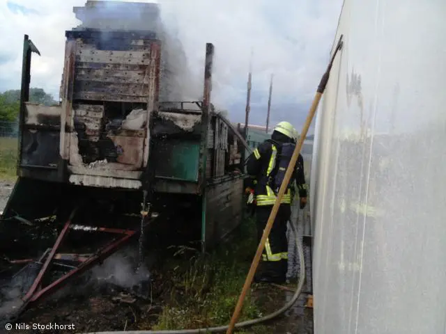 LKW Anhänger mit Schalungsmaterial brennt